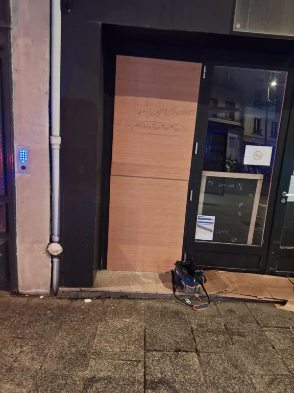 Porte de commerce condamnée par un panneau bois après effraction